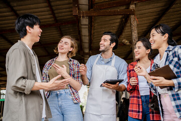 Portrait of smiling young people group student with the teacher in livestock barn with feeding black cows and buffalo. Animal husbandry and cattle farming jobs