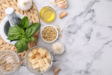 Different ingredients for cooking tasty pesto sauce on white marble table, flat lay. Space for text