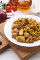 Plate of delicious rice with chicken on white wooden table, closeup