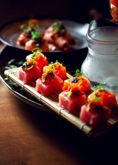 plate of cubed sushi, salmon and tuna with vegetable decoration with soft light from the background.