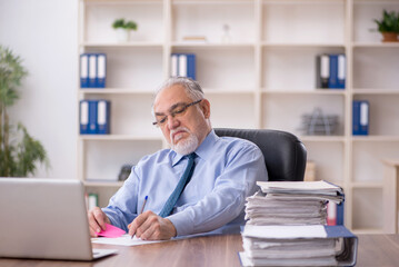 Old male employee working in the office