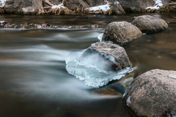 Landscape of a small river frozen in winter ice