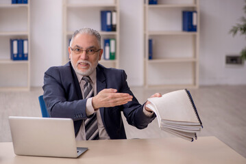 Old male employee working in the office