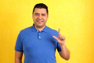 Dark-haired Latino adult man uses sign language typical of deaf people to establish a channel of...