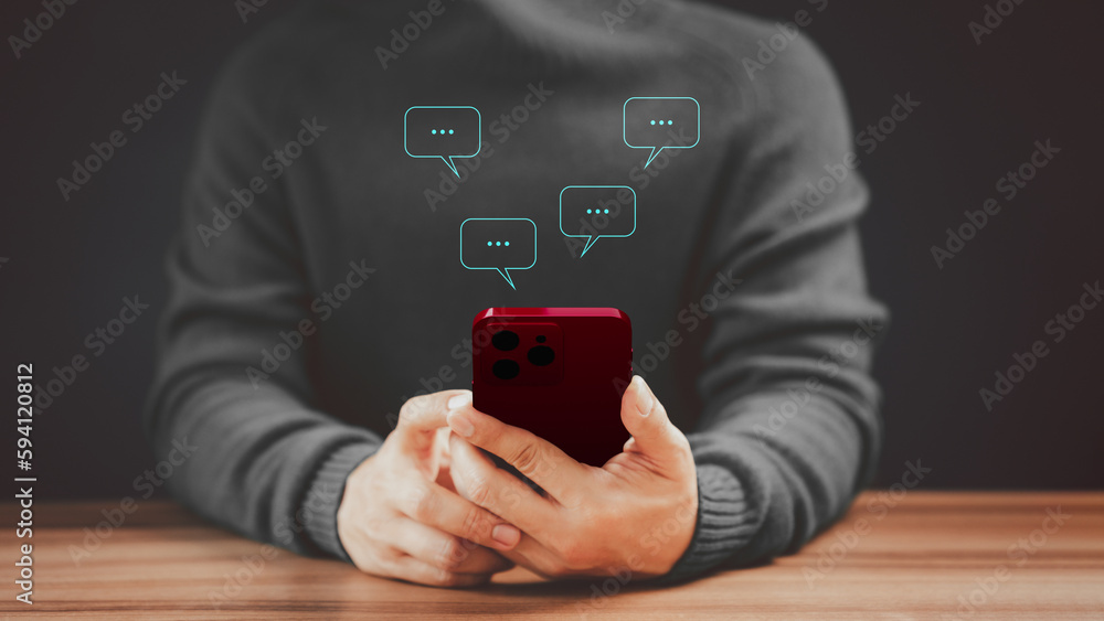 Aufkleber Social media application chat box on a mobile phone. Young man hand using a smartphone typing live chat chatting on application communication speech bubble digital web and social network concept.