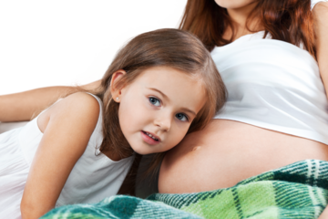 happy kid girl hugging pregnant mother's belly
