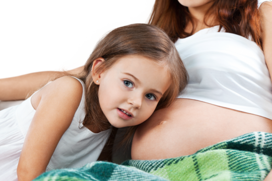 happy kid girl hugging pregnant mother's belly