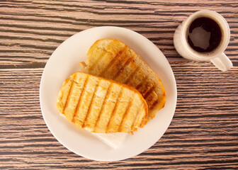 Buttered Toast on Plate with Coffee Cup, Breakfast, Top View (Brazilian Pao na Chapa)