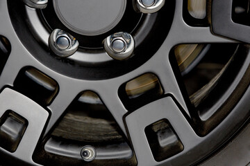 Close up of a Black Car Wheel Rim with Chrome Lug Nuts