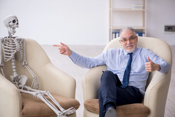 Old male psychologist meeting with skeleton