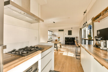 a kitchen with white cabinets and wood counter tops in the center of the image is an open door leading to another room
