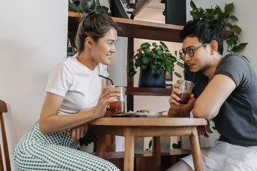 Sweet asian couple lover flirting date in the cafe.