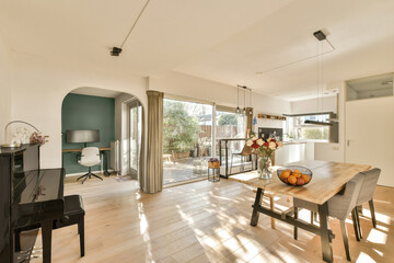 a living room and dining area with wood flooring, white walls, large sliding glass door leading to...