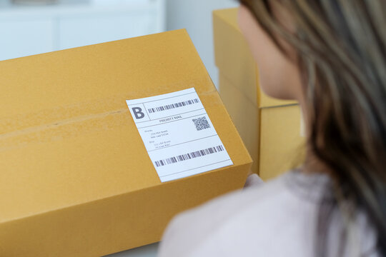 Close up of woman hand holding product box with bar code for delivering to customer, online shopping, small business