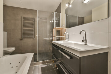 a bathroom with a tub, sink and bathtub in the middle of the room on the right is a large mirror