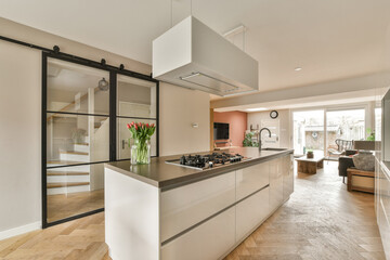 a modern kitchen with wood flooring and white cabinetd appliances on the counters in the center of...
