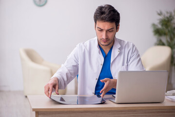 Young doctor radiologist sitting at the hospital