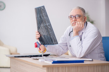 Old male doctor radiologist working at the hospital