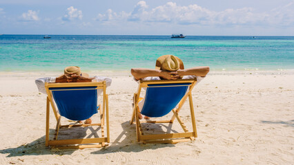 beach chairs at the beach of Koh Kradan island in Thailand couple men and woman relax on the beach