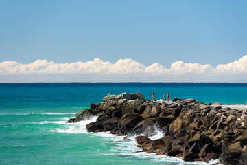 View past the Coolangatta seawall to the ocean with clouds clouds sitting low over the horizon. Coral Sea, Gold Coast, Queensland, Australia