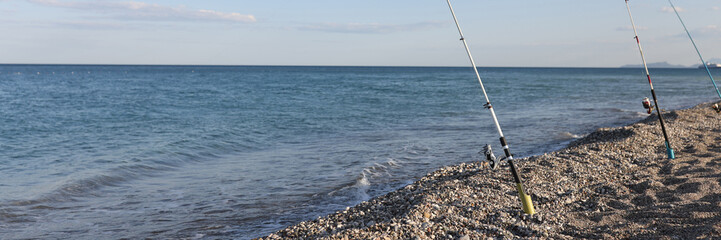 Fishing rods on sea beach, seaside landscape