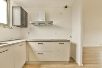 a kitchen with white cabinets and black counter tops on the floor in front of the sink is an open window