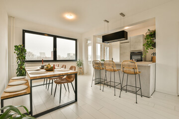 a kitchen and dining area in a modern apartment with white tiles on the floor, large windows...