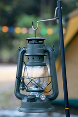 Old kerosene lamp at forest camping . Vintage lantern lighting.