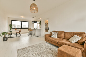 a living room with brown couches and white tiles on the floor in front of the sofa is an area rug