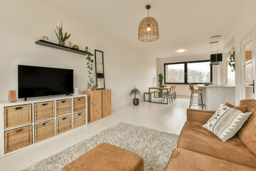 a living room with couches and a flat screen tv on the wall in front of the sofa is brown