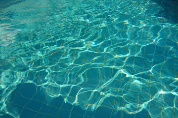 Fototapeta na wymiar Blue ripped water in swimming pool. Texture of water surface. 