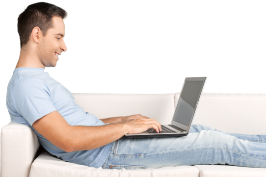 Smiling Man Using Laptop while Lying on a Couch