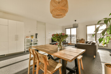 a dining table and chairs in a room with an open door leading to the living area that looks out onto the street