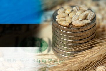Estonian flag on a grain background with coins close-up. Export of wheat and grain. World food crisis. Export logistics solution