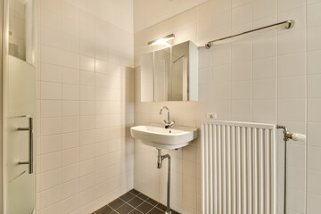 a bathroom with a sink, mirror and radiaing towel rack on the wall next to the bathtub