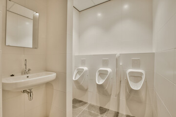 a bathroom with two urves on the wall and a sink in the other part of the room is white