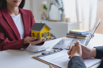 Real estate agent and customer make contract to buy and sell house and land approval of a contract to buy or sell a home offers mortgage loans and home insurance concept.