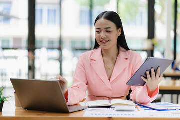Obraz premium Asian female business consultant auditor working at modern office with accounting documents and balance sheet laptop Account verification to prevent bribery in the company
