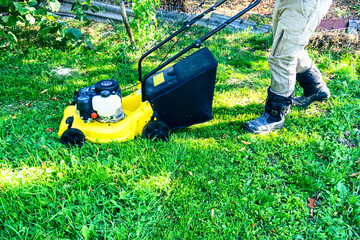 lawn mower on a sunny day, man mowing the lawn in the backyard