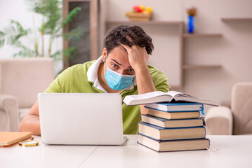 Young male student preparing for exams at home during pandemic