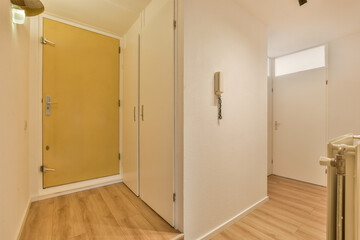 an empty room with wood floors and yellow door leading to another room in the same area, which is...