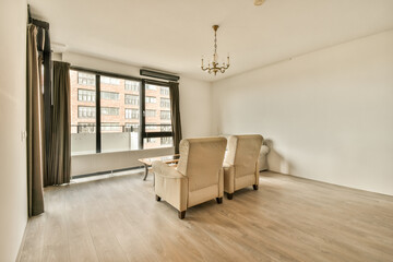 an empty living room with wood flooring and large sliding glass door leading to the balcony area in this apartment