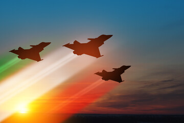 Aircraft silhouettes with flag color trails on background of sunset. Italian Air Force Day.