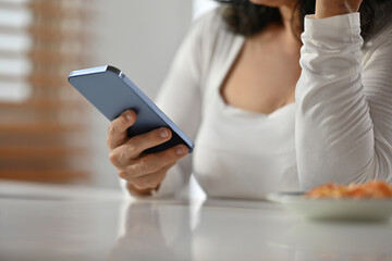 Selective focus on hand, Cropped shot of senior woman hand texting messages, chatting in social on smartphone