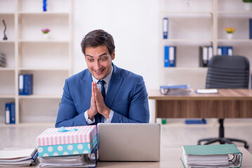 Young male employee celebrating birthday at workplace