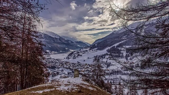 Beautiful winter images of a valley between snowy mountains covered with forests. Time lapse
