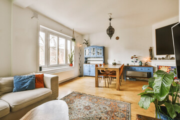 a living room with a couch, table and television set in the center of the room there is a rug on the floor