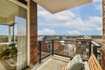 a balcony with a view of the city from it's window simh, and there is an empty chair on the