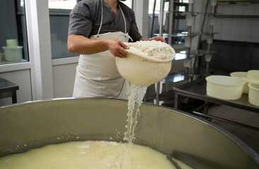 Concept of cheese production process. Draining the whey through sieve.