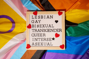 LGBTQIA description frame on Rainbow LGBTQIA flag made from silk material. LESBIAN, GAY, BISEXUAL,...